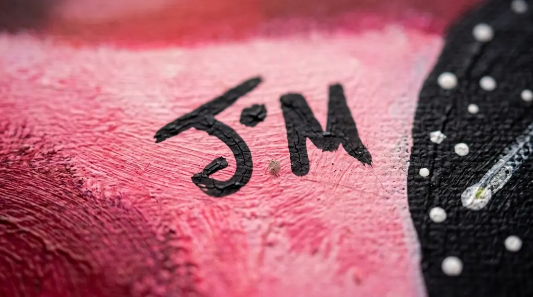 The J.M. signature painted in black